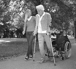 Two people walking on a sidewalk outside